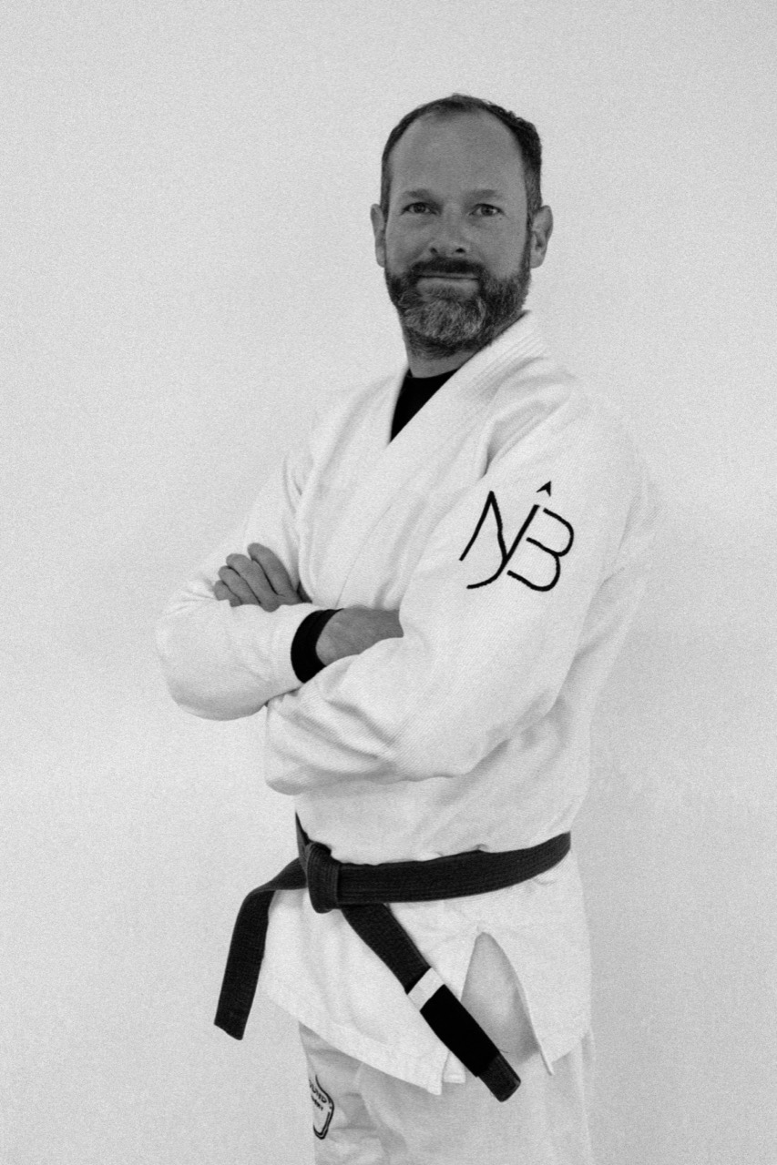 Coach Robin Heijl wearing a white gi and brown belt