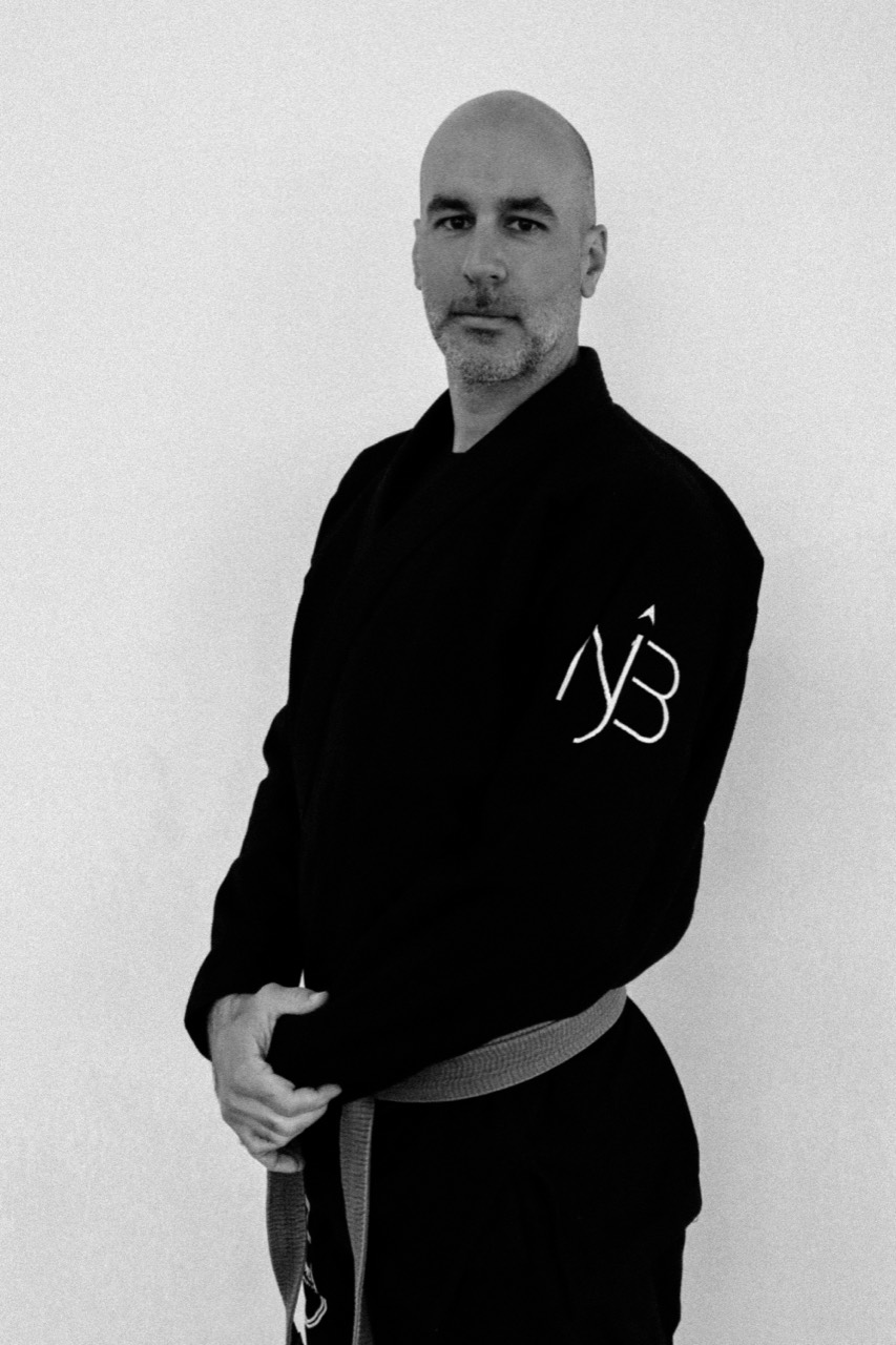 Coach Sasan Ghinani wearing a black gi and purple belt